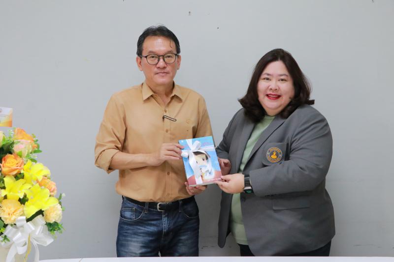  ผศ.ดร.อรอุษา สุวรรณประเทศ คณบดีคณะมนุษยศาสตร์ มอบช่อดอกไม้ แสดงความยินดีแด่รองศาสตราจารย์ สุทัศน์ เยี่ยมวัฒนา 